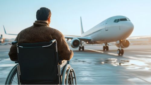 Fliegen mit Rollstuhl: Mann wird in einem Rollstuhl ins Flugzeug gebracht. Fliegen mit Rollstuhl: Mann wird in einem Rollstuhl ins Flugzeug gebracht.